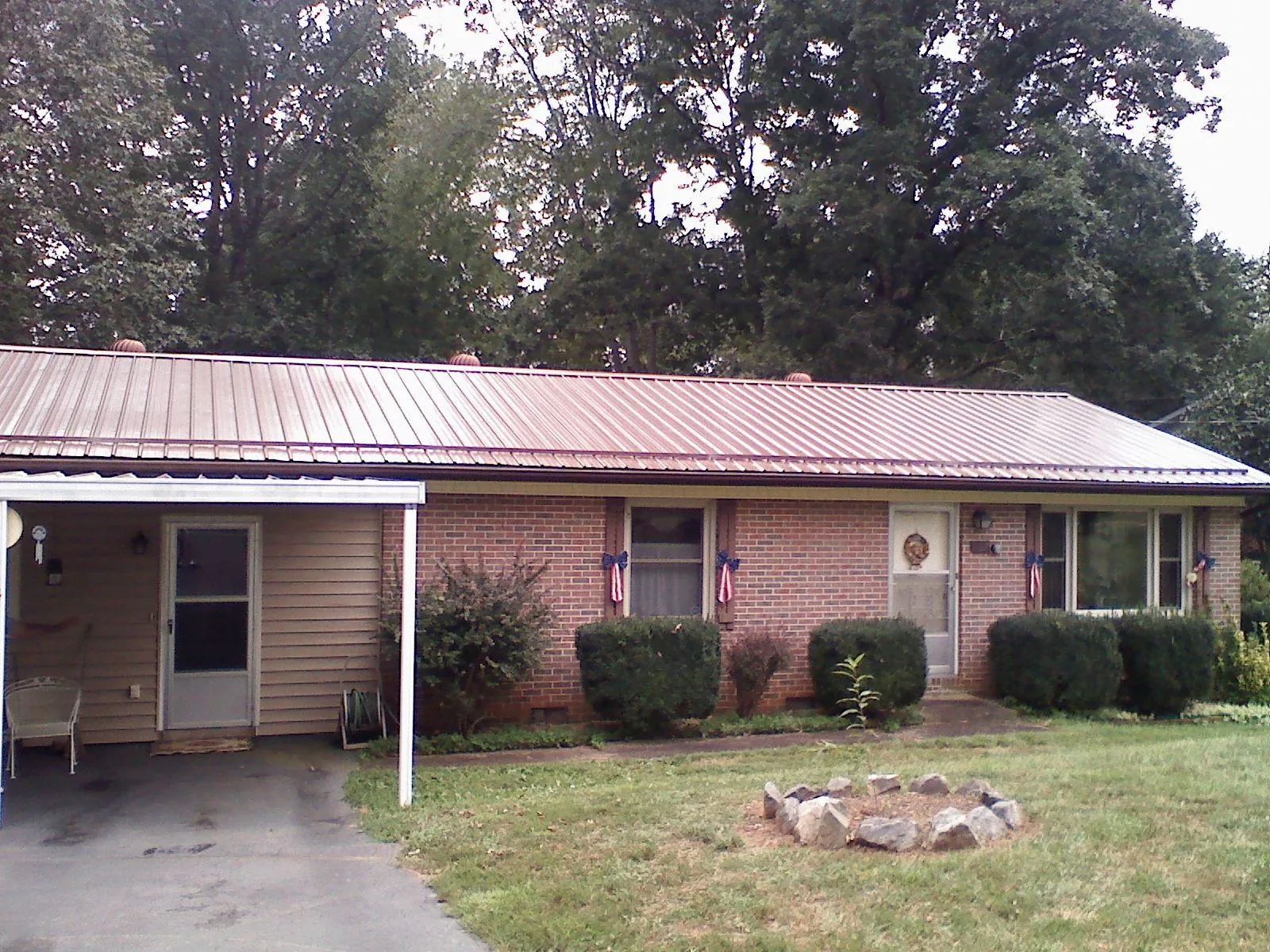 Bronze metal roof and carport on a brick ranch home in Hudson